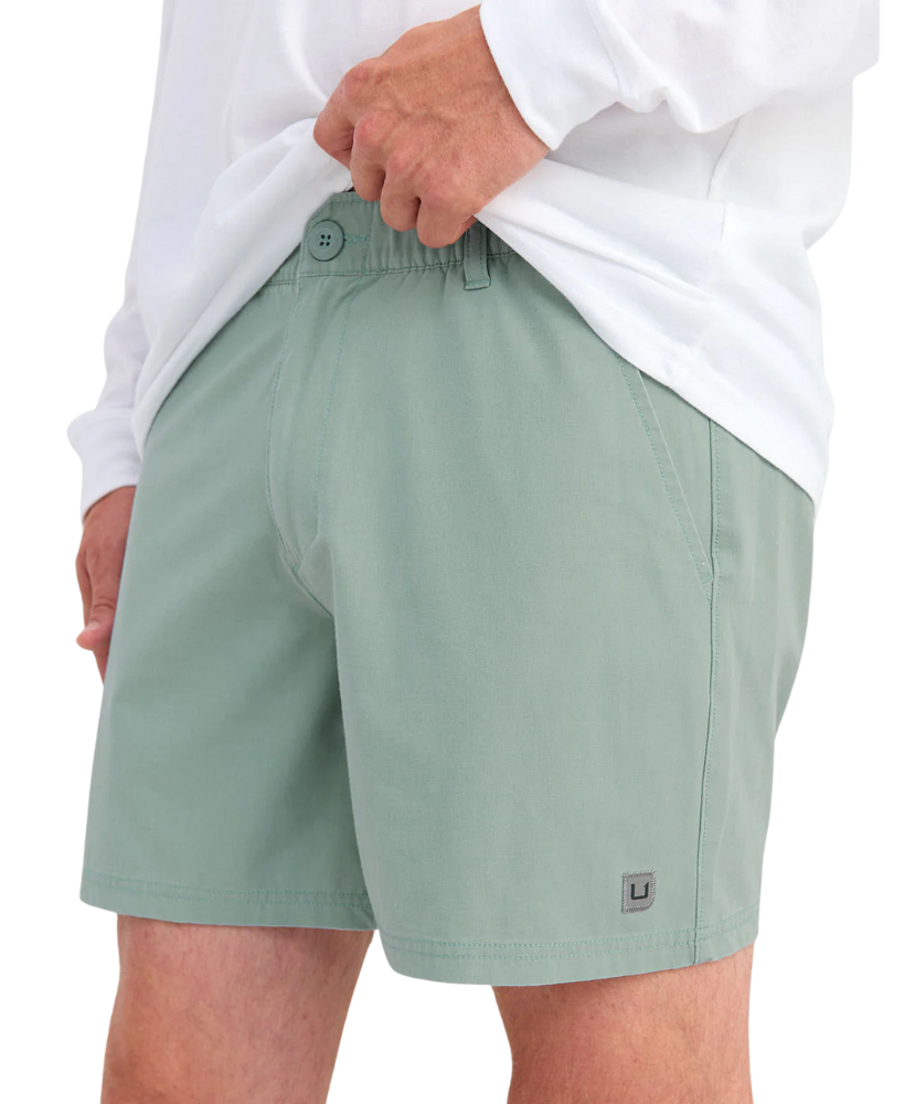 Person wearing LIGHT GREEN HUK shorts on a white background