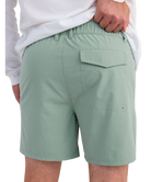 Person wearing LIGHT GREEN HUK shorts on a white background