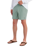 Person wearing LIGHT GREEN HUK shorts on a white background