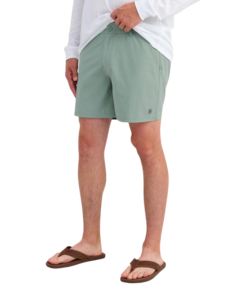 Person wearing LIGHT GREEN HUK shorts on a white background