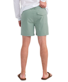 Person wearing LIGHT GREEN HUK shorts on a white background