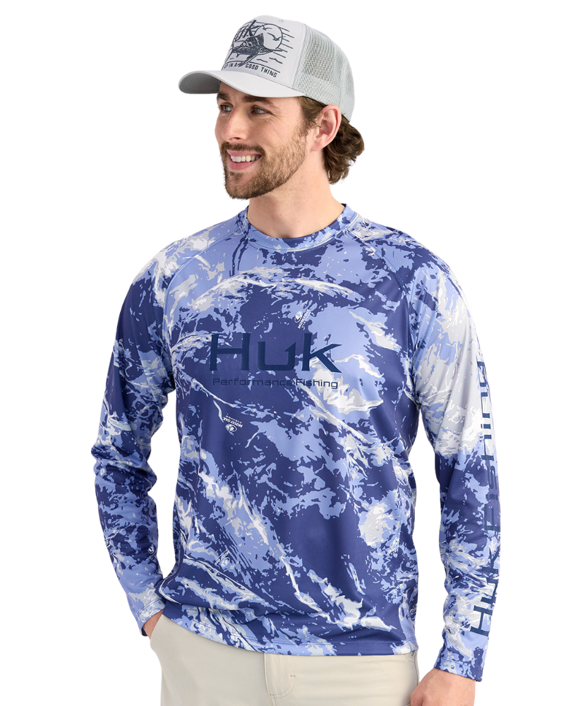 Man wearing a blue camouflage long-sleeve shirt with HUK logo on a white background