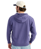Man wearing a BLUE purple hoodie with a logo, standing against a white background