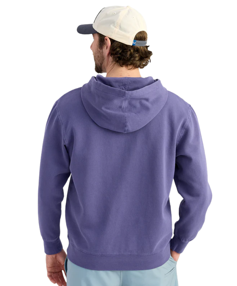 Man wearing a BLUE purple hoodie with a logo, standing against a white background
