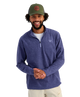 Man wearing a blue pullover with a HUK logo and a green cap with a logo on a white background
