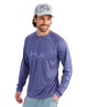 Man wearing a purple Huk long-sleeve shirt and cap on a white background