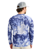 Man wearing a blue camouflage long-sleeve shirt with 'Huk' branding on the back.