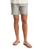 Person wearing light gray shorts on a white background