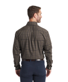 Man wearing a Southern Marsh plaid shirt and dark pants on a white background