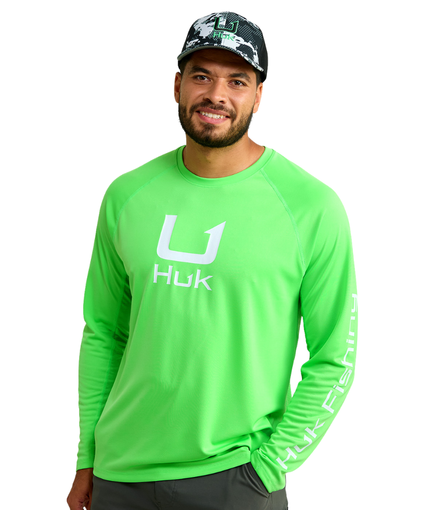 Man wearing a bright green long-sleeve shirt with 'Huk' logo on a white background
