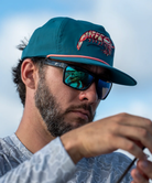 Teal LOCAL BOY cap with a shrimp design on a white background