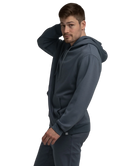 Man wearing a blue hoodie and pants with white sneakers on a white background