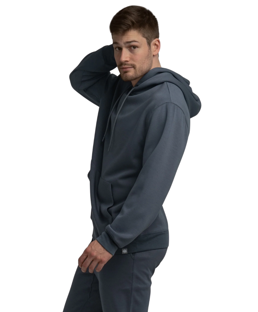 Man wearing a blue hoodie and pants with white sneakers on a white background