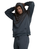Person wearing a dark blue hoodie and pants on a white background