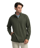 Man wearing a green pullover with a quarter zip on a white background