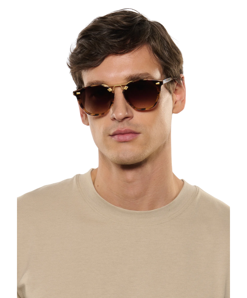 Man wearing a pair of Krewe sunglasses on a white background