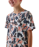 Child wearing a camo patterned t-shirt and cap on a white background