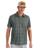 Man wearing a patterned green polo shirt and a tan and brown cap on a white background