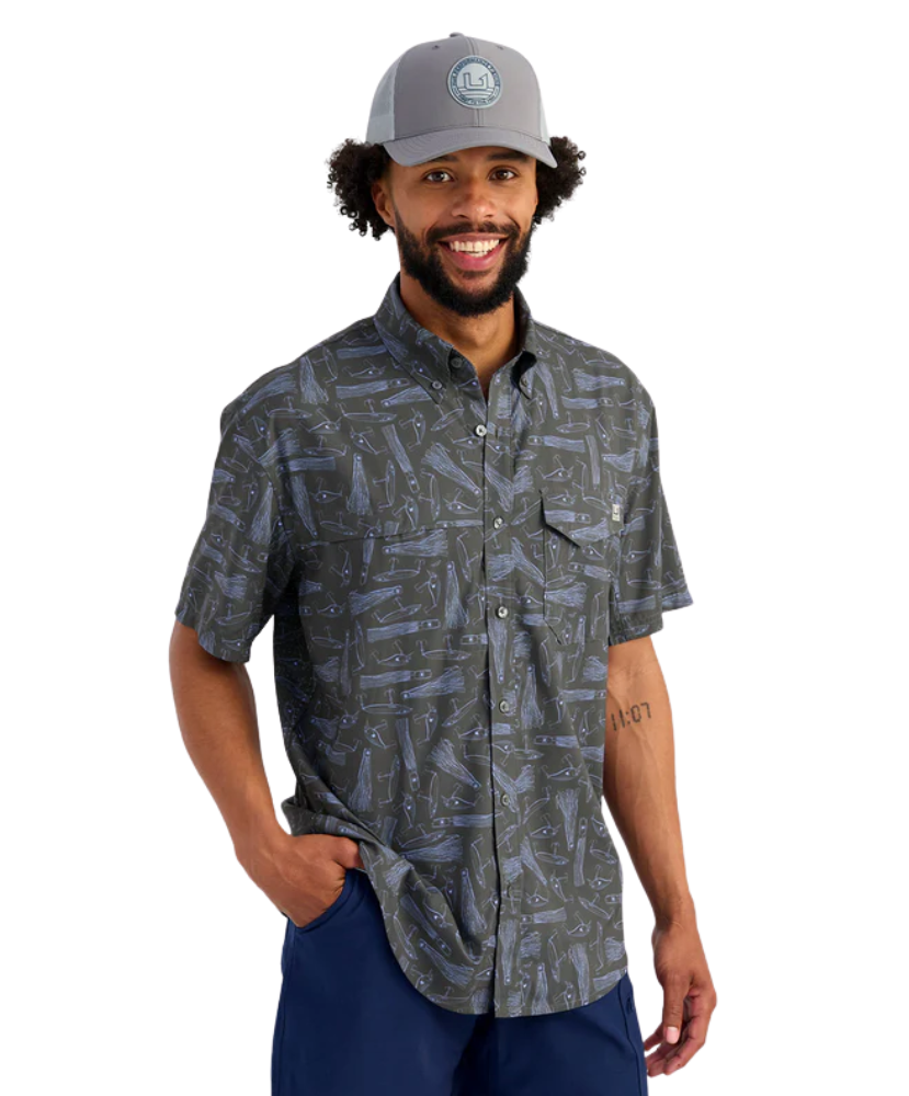 Man wearing a LURES patterned shirt and cap on a white background