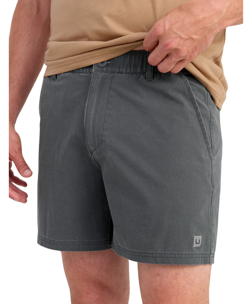 Person wearing gray HUK shorts on a white background