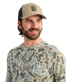 Man wearing a camouflage t-shirt and cap with a logo on a white background
