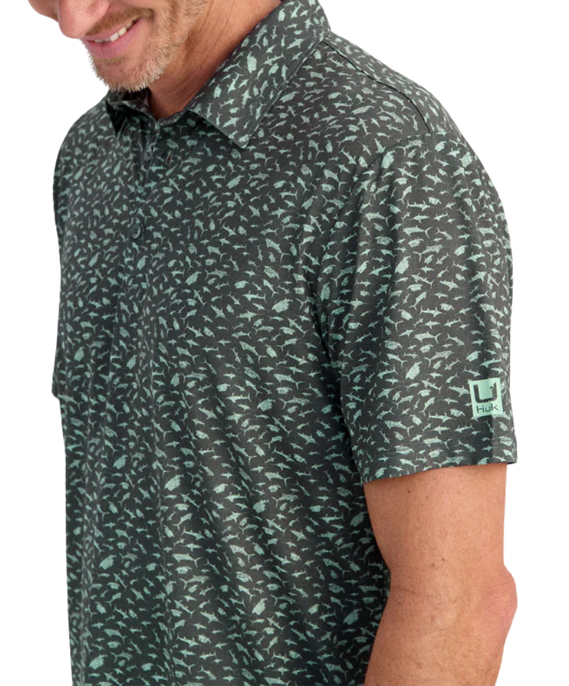 Man wearing a FISH patterned polo shirt with a visible brand logo on a white background