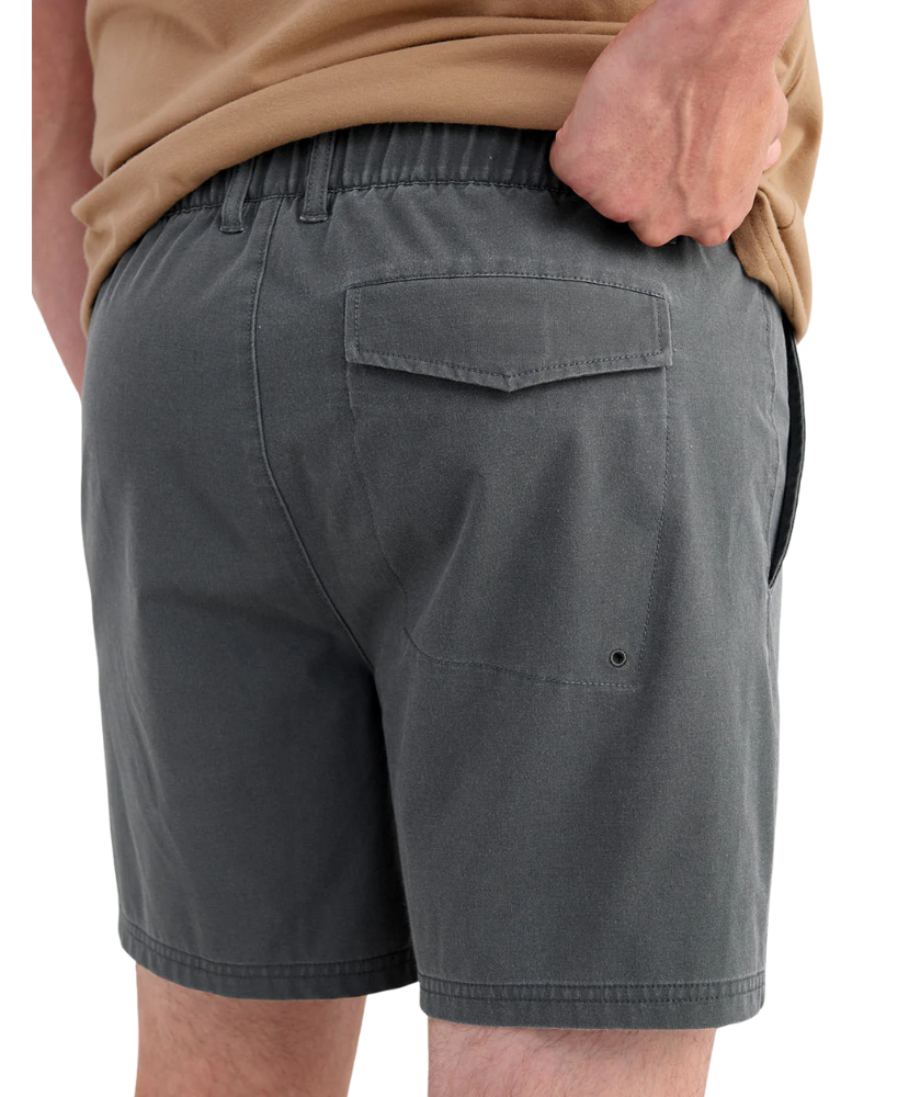 Person wearing gray HUK shorts on a white background