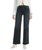 Woman wearring washed black denim pants with a high rise and wide leg