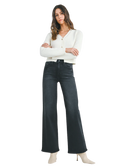Woman wearring washed black denim pants with a high rise and wide leg