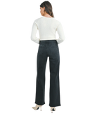 Woman wearring washed black denim pants with a high rise and wide leg