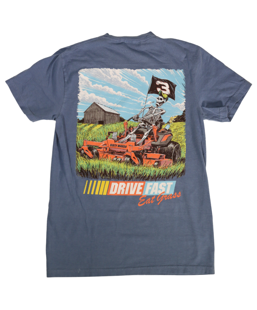 Blue t-shirt with a graphic of a skeleton driving a lawn mower and text 'Drive Fast Eat Grass' on a white background.