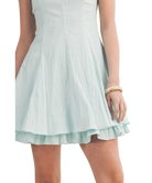 Light blue dress with ruffled hem on a white background