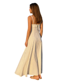 Woman wearing a long, light-colored dress with thin straps on a white background