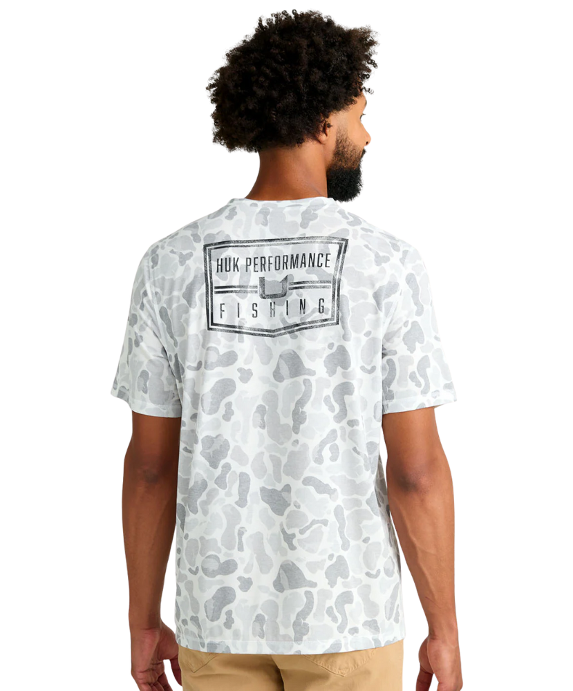 Man wearing a white camouflage t-shirt with 'Huk Performance Fishing' logo on the back.