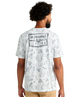 Man wearing a white camouflage t-shirt with 'Huk Performance Fishing' logo on the back.