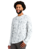 Man wearing a long-sleeve white camouflage shirt on a white background