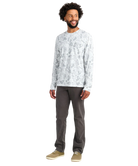 Man wearing a white long-sleeve shirt with a white camoflage pattern and dark pants on a white background