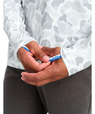 Close-up of hands holding a blue pen with a white shirt and gray pants in the background