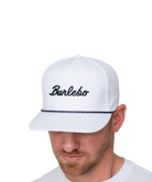 White cap with 'Burlebo' logo worn by a person on a white background