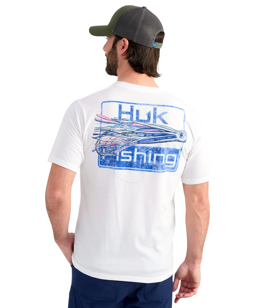 Man wearing a white Huk Fishing t-shirt with a fishing lure graphic on the back, standing against a white background.