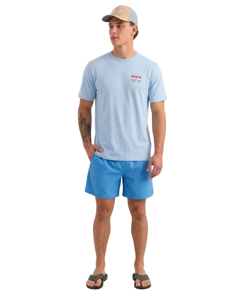 Man wearing a light blue t-shirt and shorts with a cap on a white background