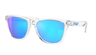 Oakley sunglasses with a clear transparent frame and vibrant blue mirrored lenses, shown on a solid white background.