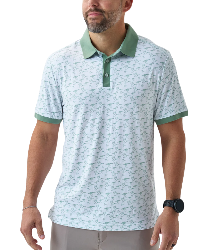 Man wearing a white duck and waterfowl patterned polo shirt with green accents on a white background
