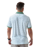 Man wearing a white duck and waterfowl patterned polo shirt with green accents on a white background
