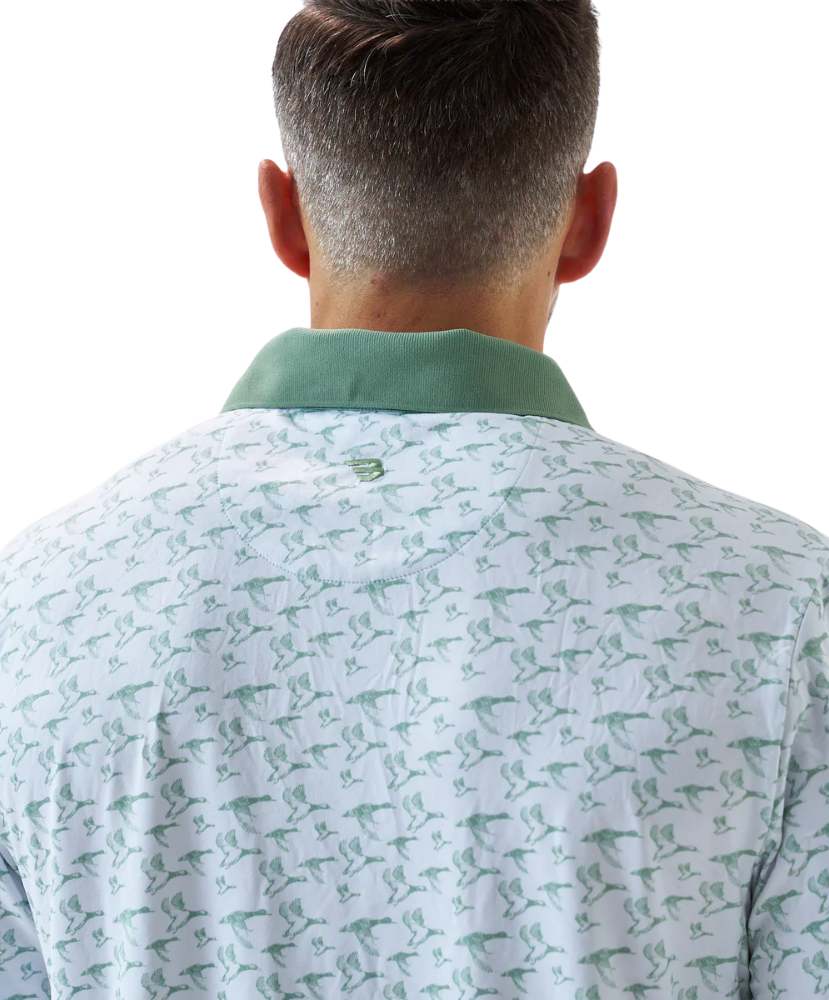 Man wearing a white duck and waterfowl patterned polo shirt with green accents on a white background