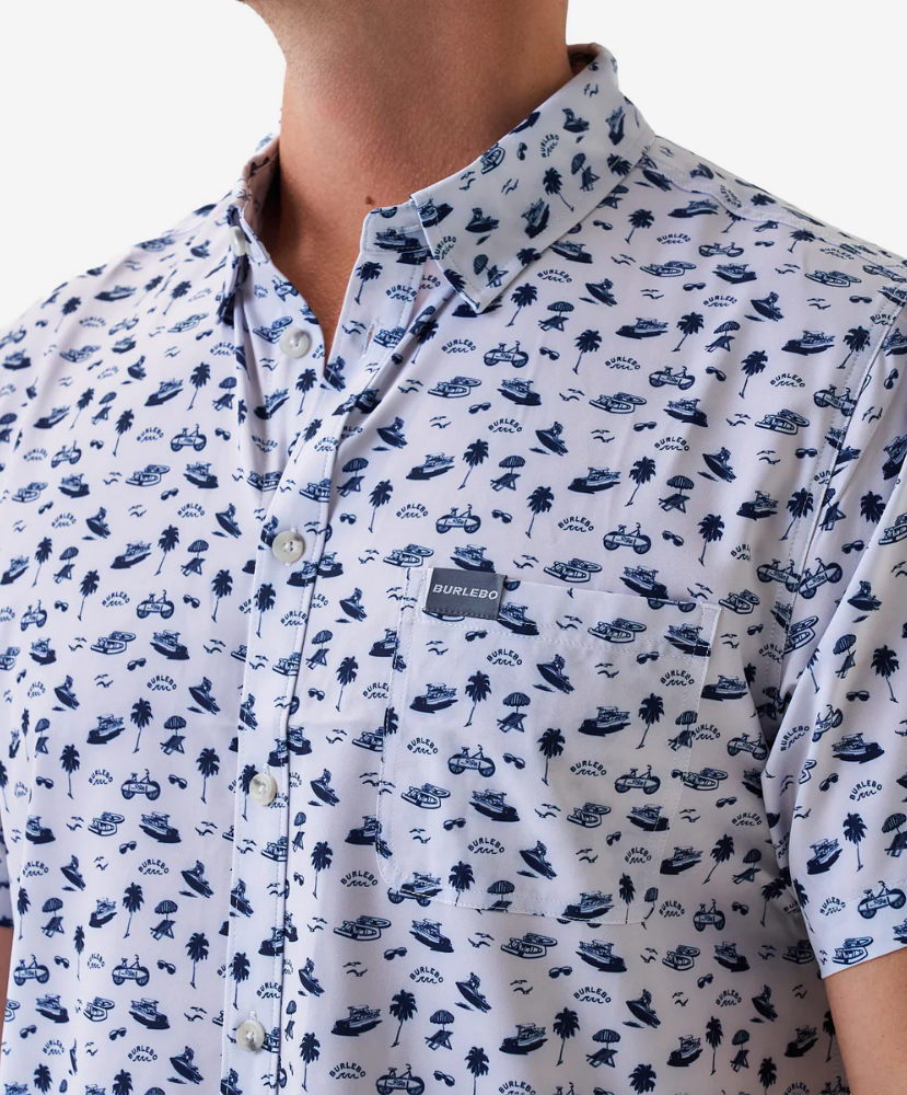 Man wearing a white short-sleeve button down shirt with a blue coastal pattern on a white background
