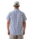 Man wearing a white short-sleeve button down shirt with a blue coastal pattern on a white background