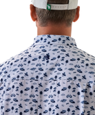 Man wearing a white short-sleeve button down shirt with a blue coastal pattern on a white background