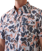 Man wearing a vintage camo patterned short-sleeve button down shirt on a white background