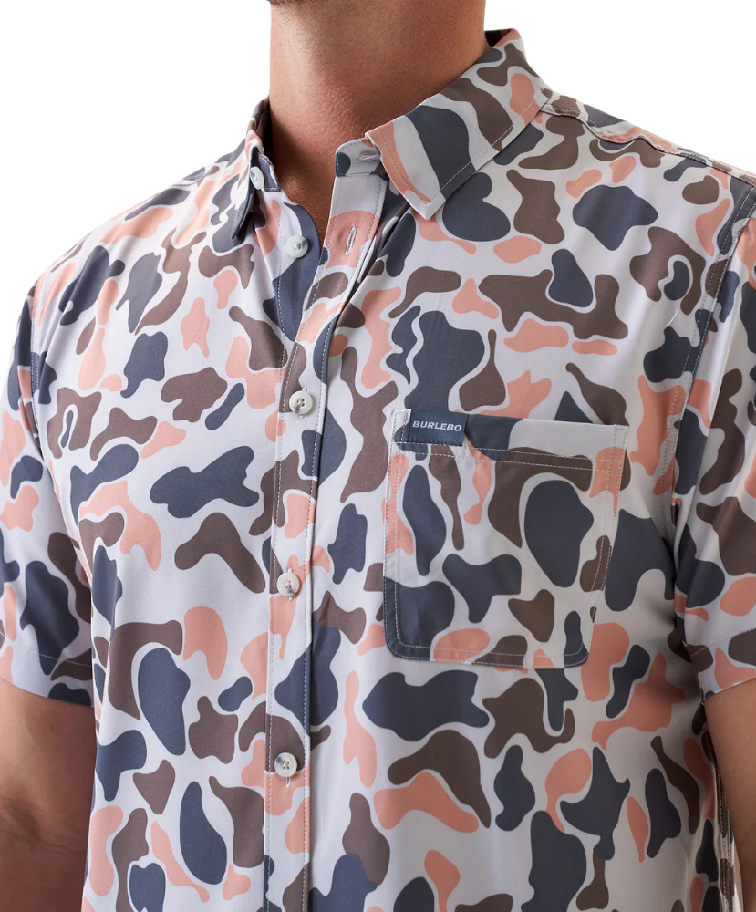 Man wearing a vintage camo patterned short-sleeve button down shirt on a white background